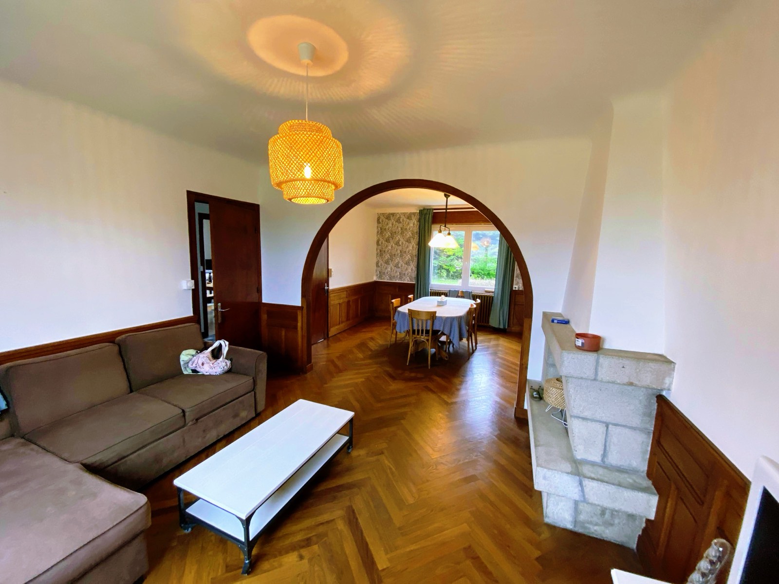Salon avec canapé et arche vers la salle à manger
